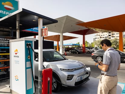 Un hombre carga su coche electrificado en un punto de recarga de una gasolinera Repsol, en una imagen cedida por la empresa.